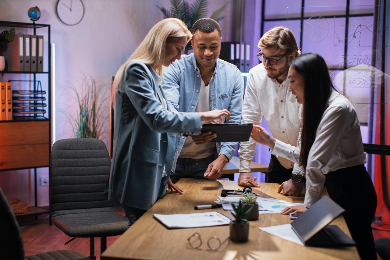 team of financial experts using tablet during brainstorming